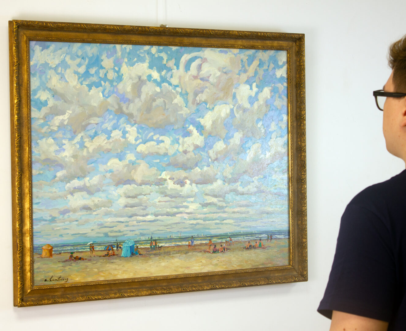 A viewer admiring André Hambourg’s 'Temps Doux à Deauville en Août' on a white gallery wall, appreciating its vibrant colors and impressionistic beach scene.