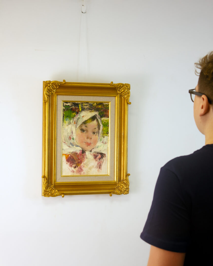 A viewer admiring Girl with White Scarf by Nicolai Fechin in an exhibition space, illustrating the artwork’s scale and impact within a room.