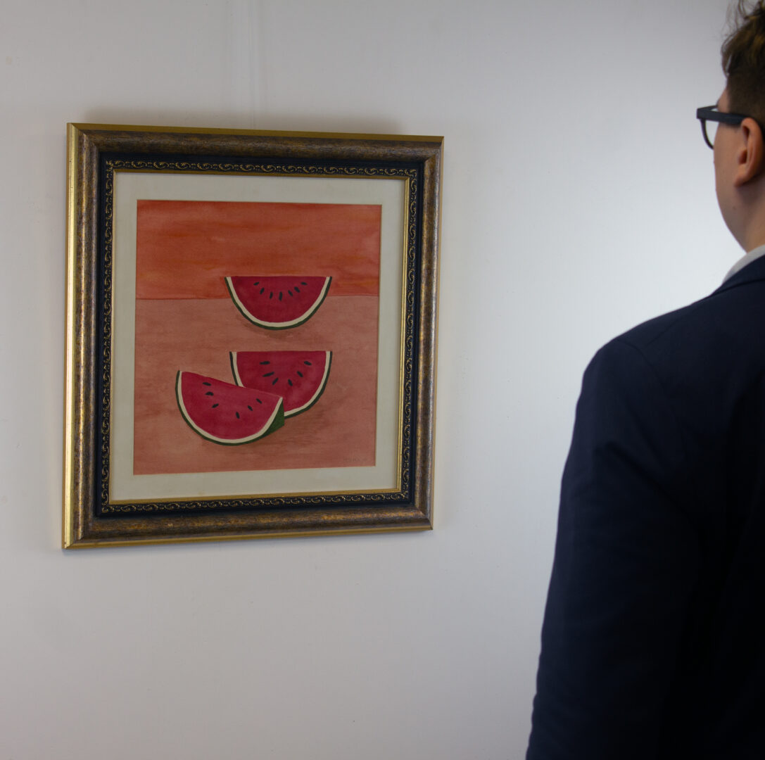 A person observing "Sandías, 1972" by Rufino Tamayo in a gallery setting, highlighting the scale and impact of the artwork.