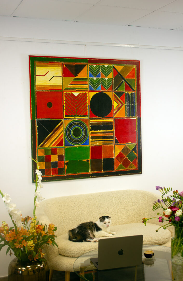 "Ankuran" (1987) by Sayed Haider Raza displayed in an elegant interior setting, showcasing its bold geometric patterns and vibrant palette.