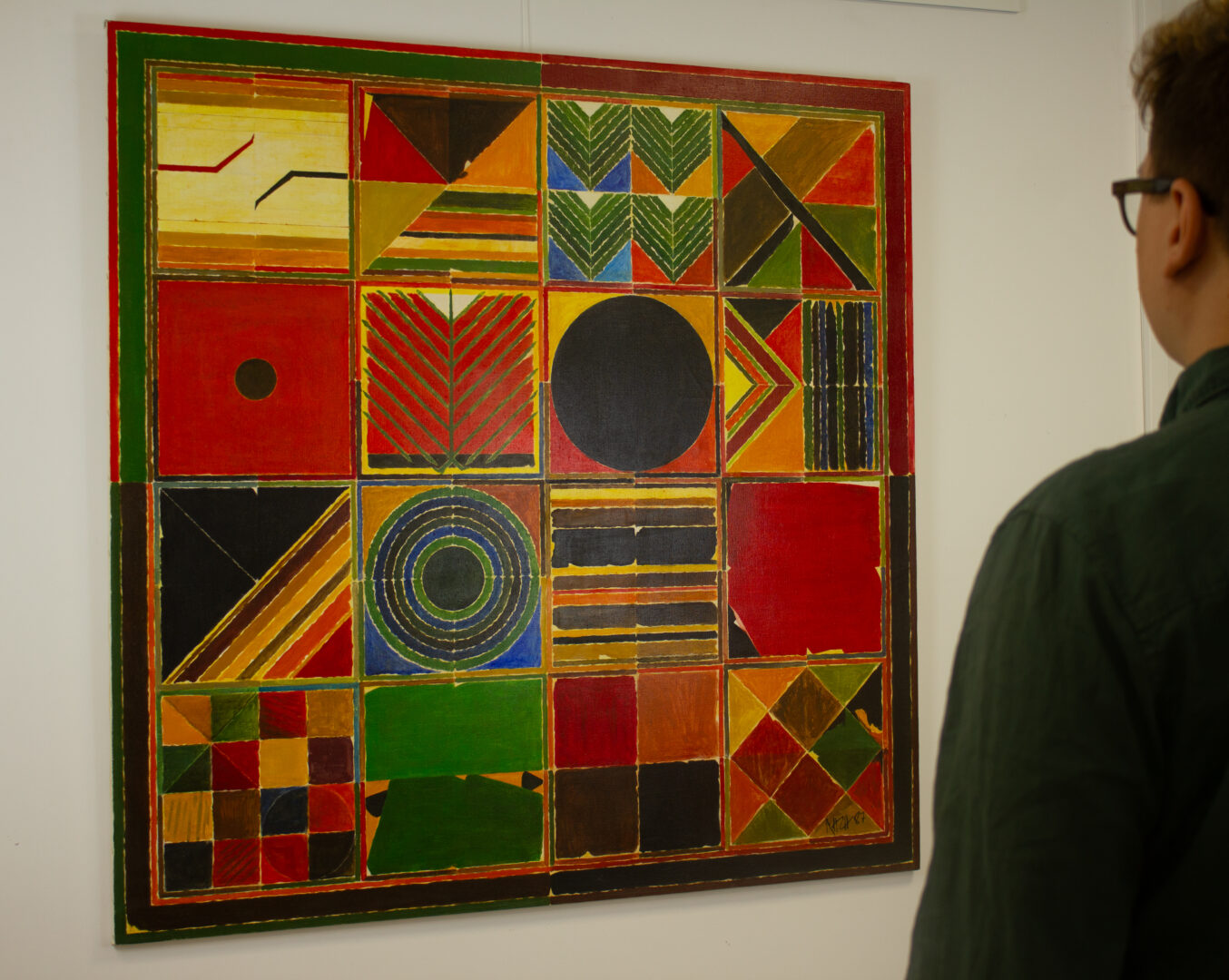 A viewer observing "Ankuran" (1987) by Sayed Haider Raza, highlighting the scale and striking presence of the artwork in an exhibition setting.