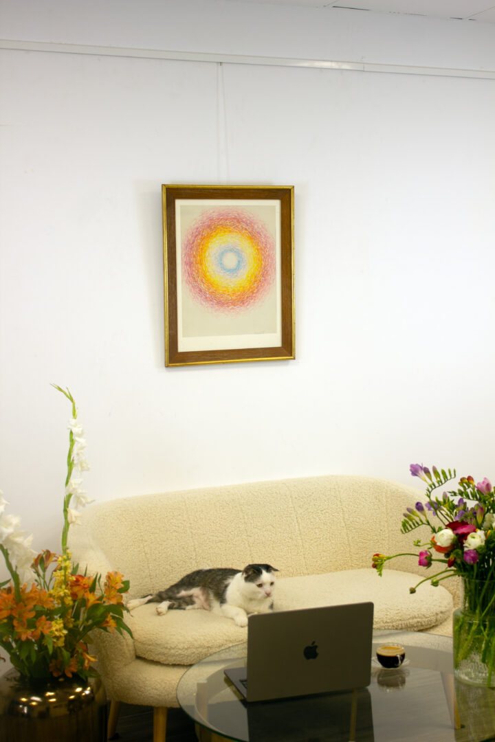 Circle, 1971 displayed in a contemporary interior above a couch with flowers.