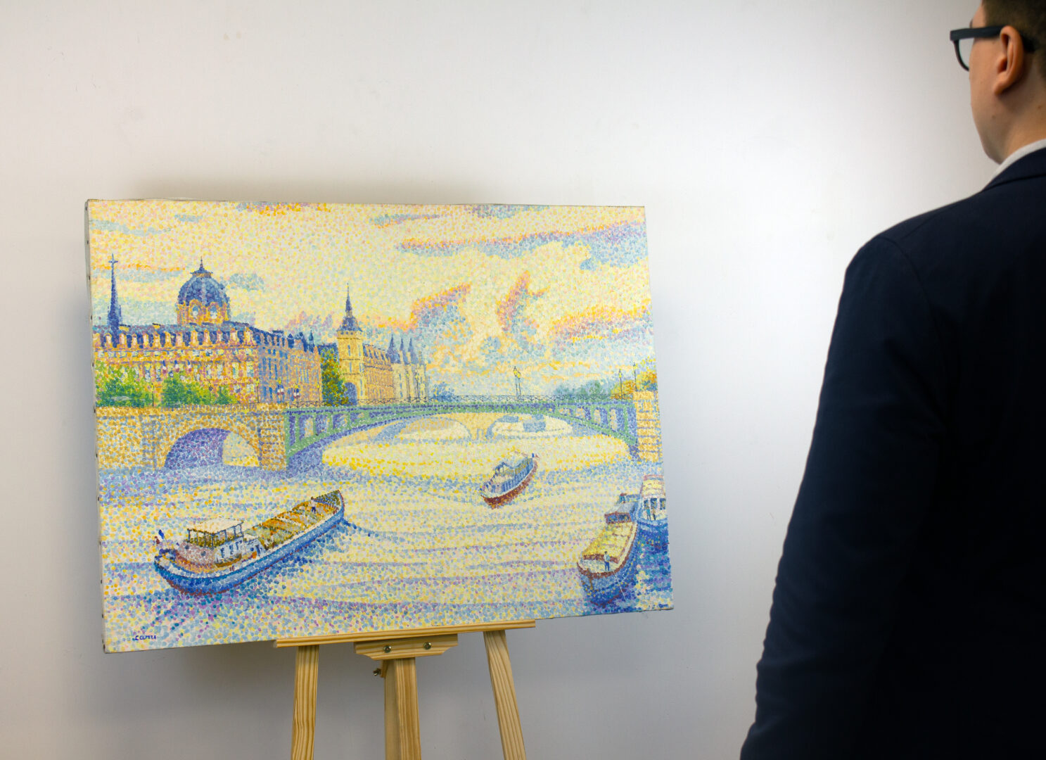 "Paris la Conciergerie" by Yvonne Canu displayed with a person for scale, highlighting the dimensions and impact of the painting.