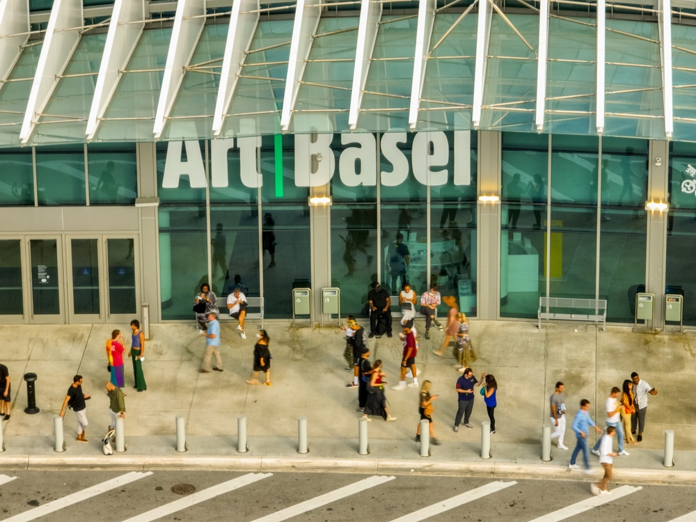 Art Basel entrance with visitors walking outside the modern exhibition center. This major international art fair showcases contemporary and fine art, attracting collectors, investors, and art enthusiasts from around the world.