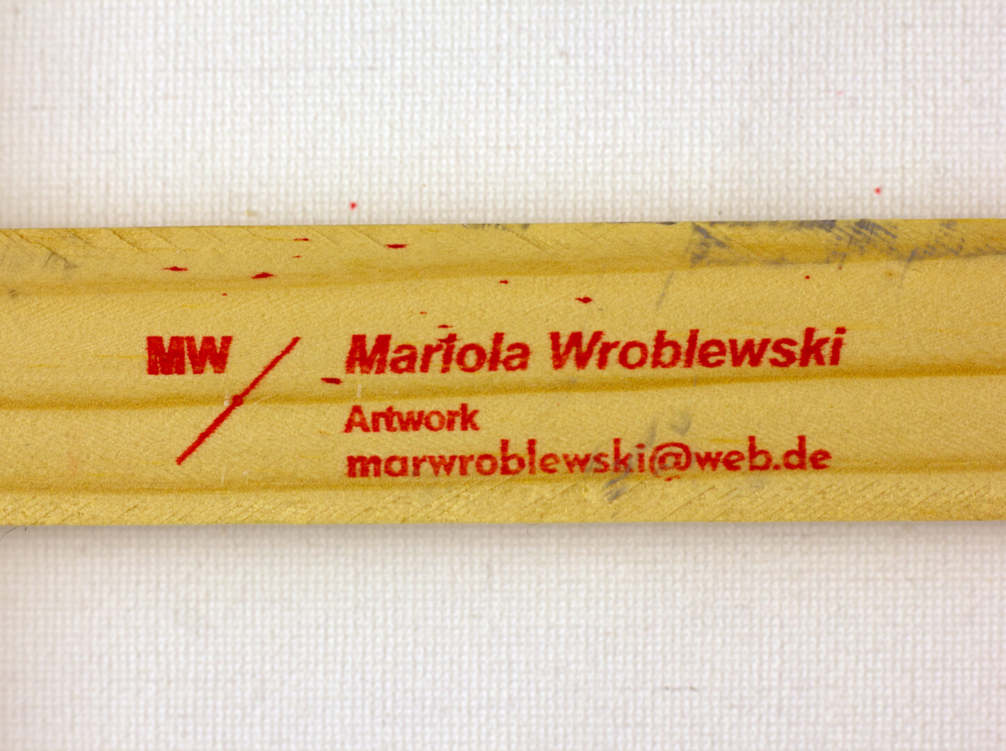 Red stamp with artist’s name, contact, and initials on the back stretcher of Jungle.