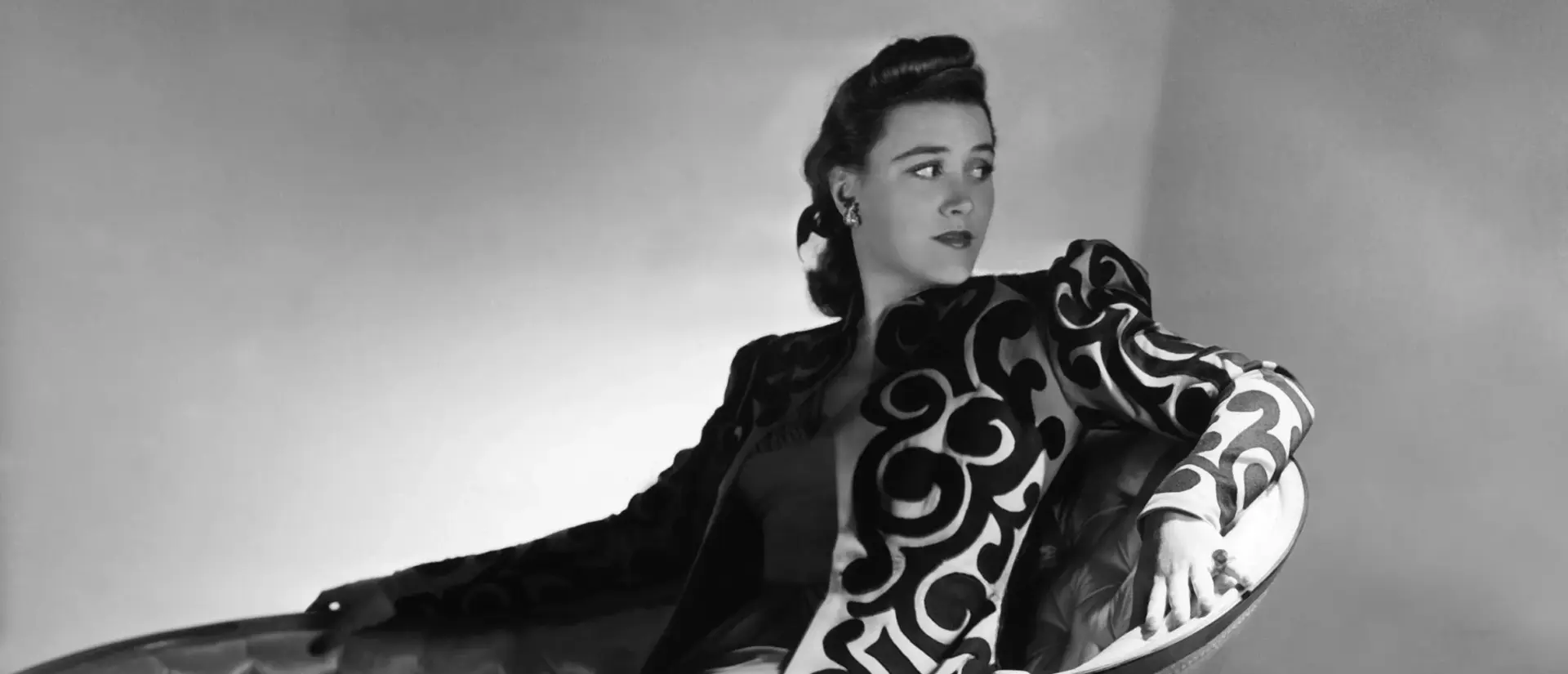 Bridget Tichenor Surrealist Painter modeling haute couture patterned gown on chaise lounge